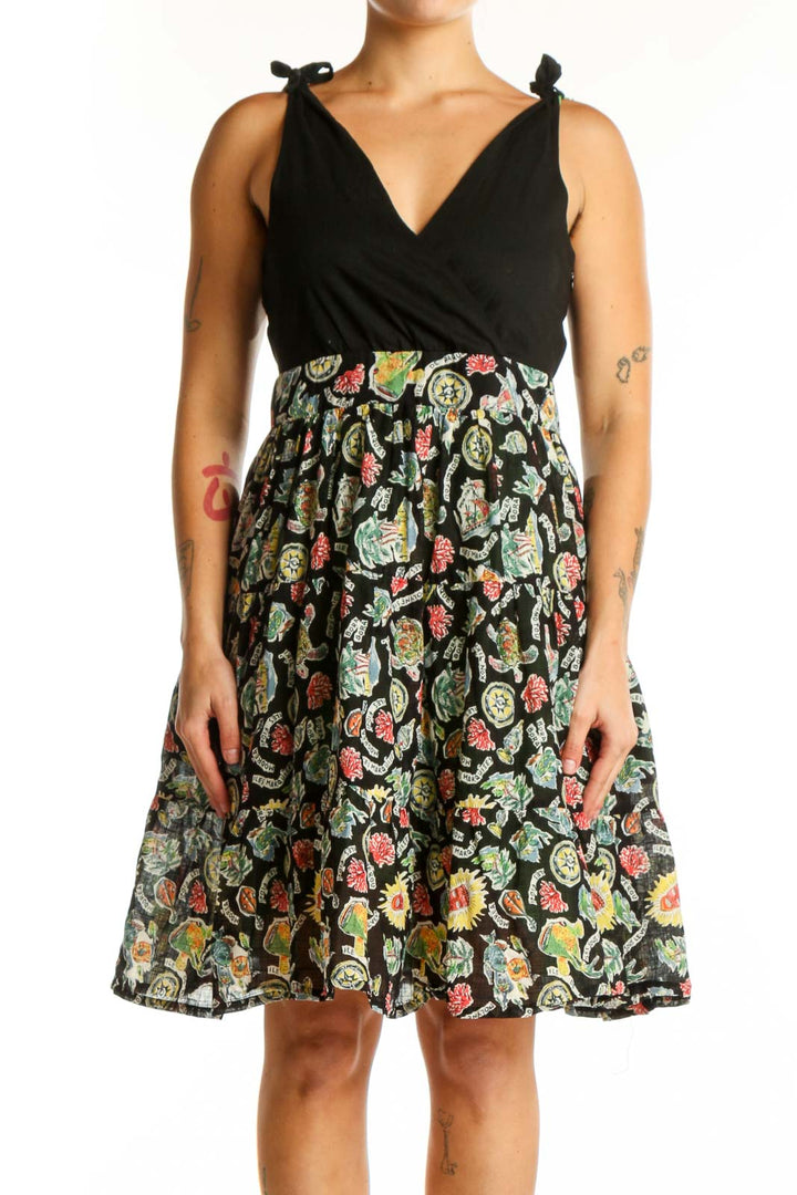 Black wrap midi dress with vibrant floral print skirt, tie-shoulder details, and V-neckline