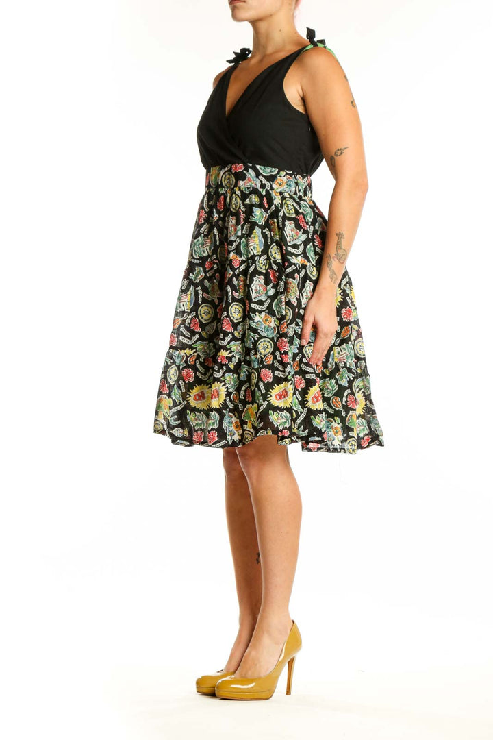 Black wrap midi dress with vibrant floral print skirt, tie-shoulder details, and V-neckline