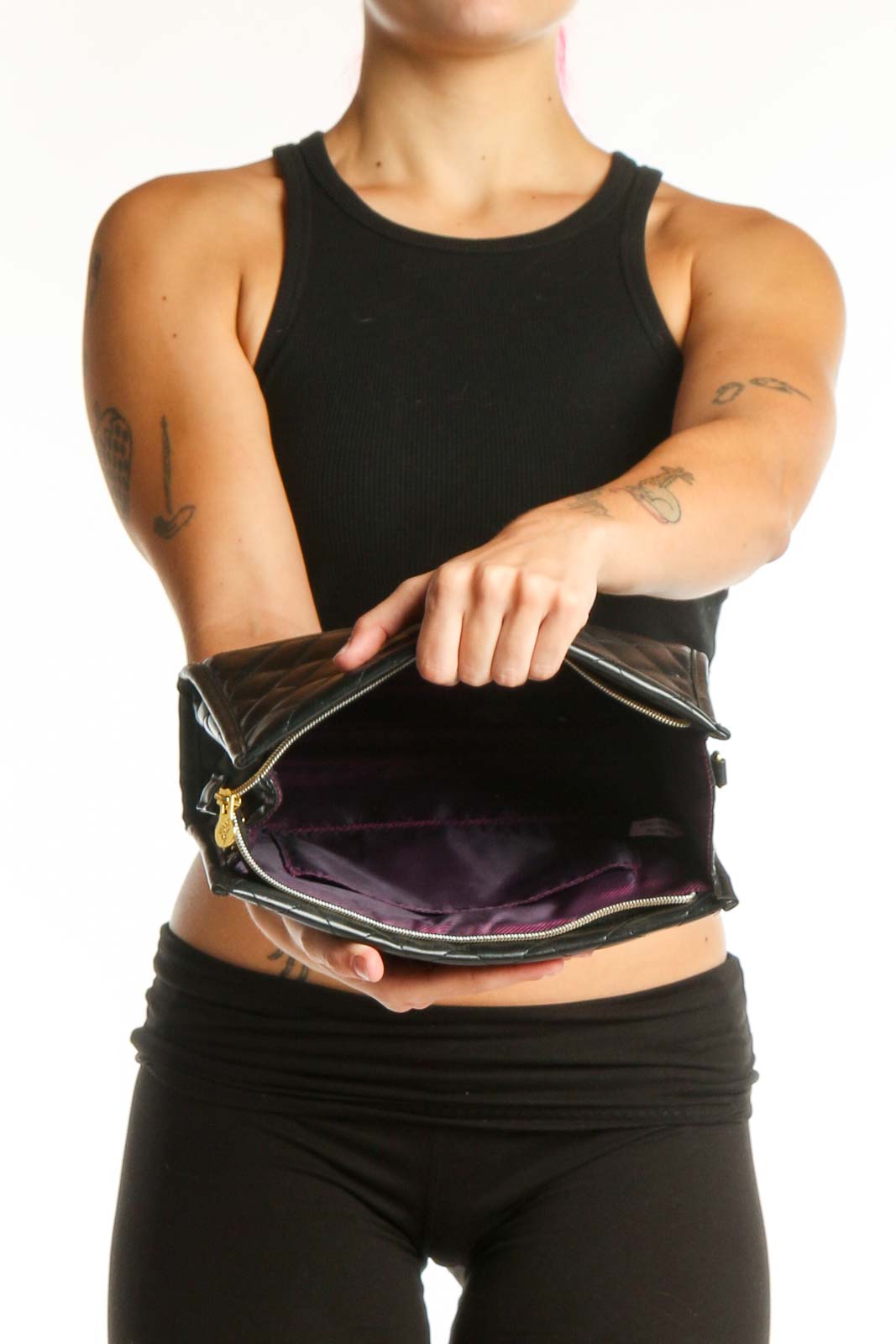 Black quilted crossbody bag worn on shoulder, showing side profile and adjustable gold chain strap
