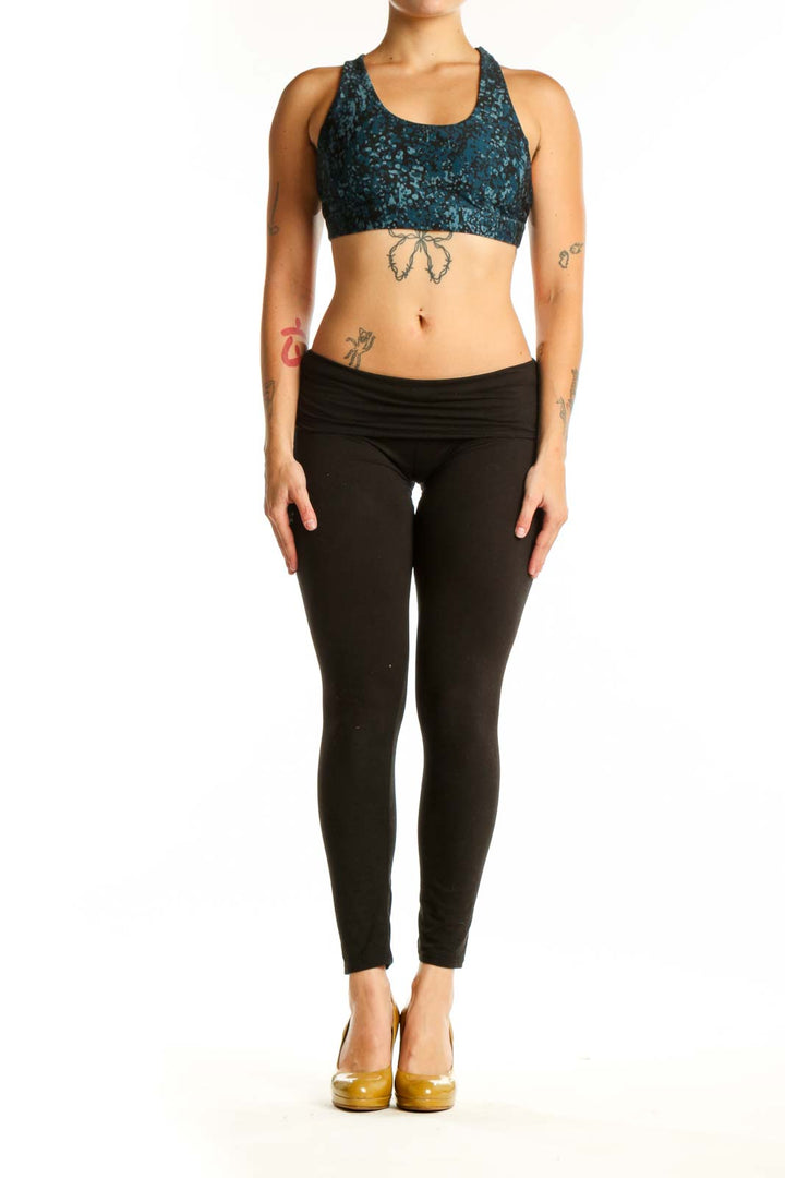 Teal velvet racerback sports bra with scoop neckline, front view on model wearing black leggings