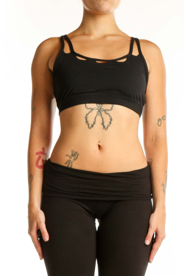 Black strappy sports bra with cutout details front view on model