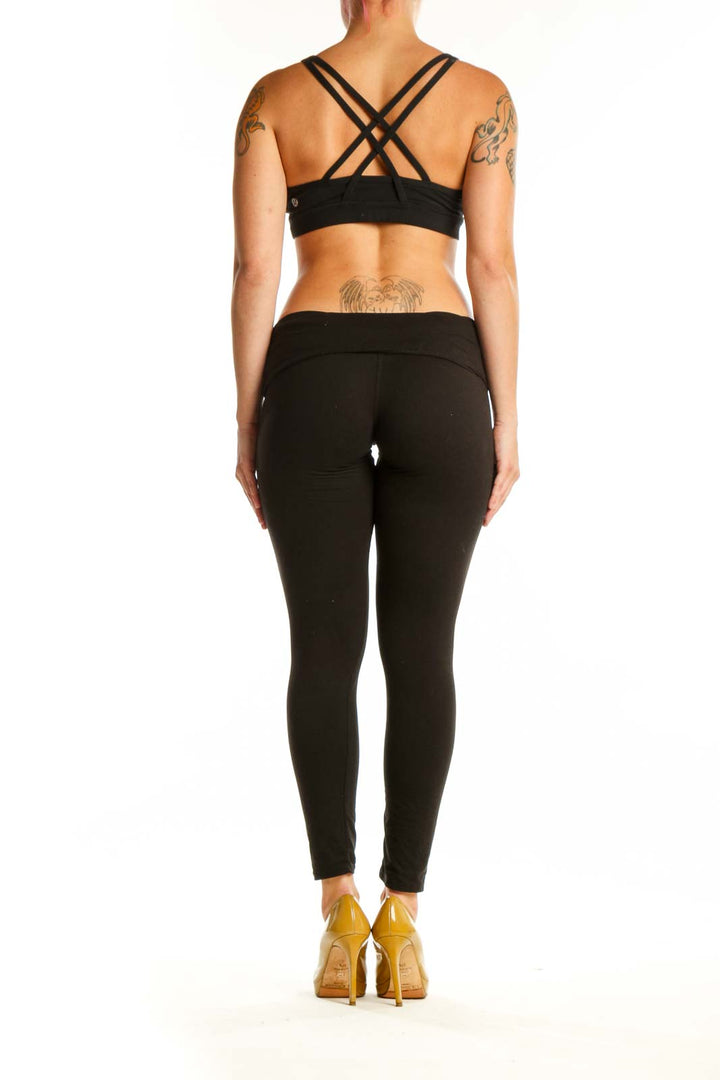 Black strappy sports bra back view showing supportive design and modern aesthetic