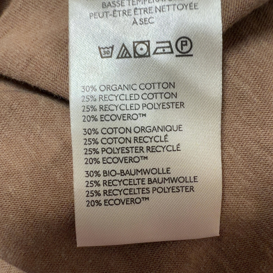 Woman wearing tan organic cotton crew neck t-shirt by WE THE FREE, back view with side profile
