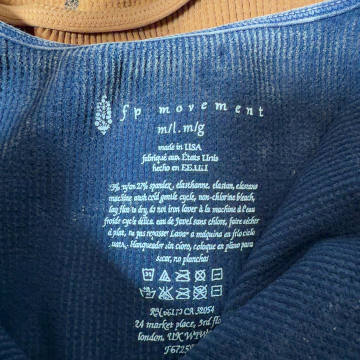Navy ribbed crop tank top back view showing fitted silhouette and distressed hem detail