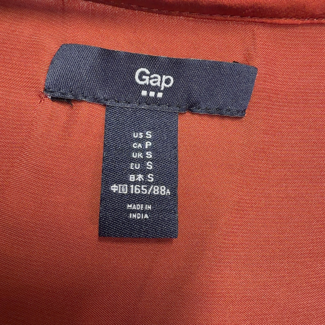 Red V-neck blouse with three-quarter sleeves, back view, styled with black pants