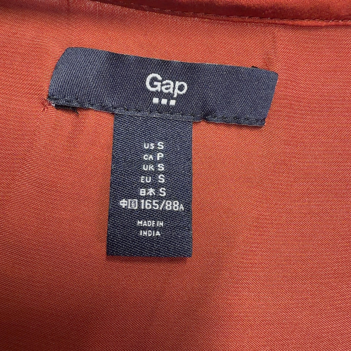 Red V-neck blouse with three-quarter sleeves, back view, styled with black pants