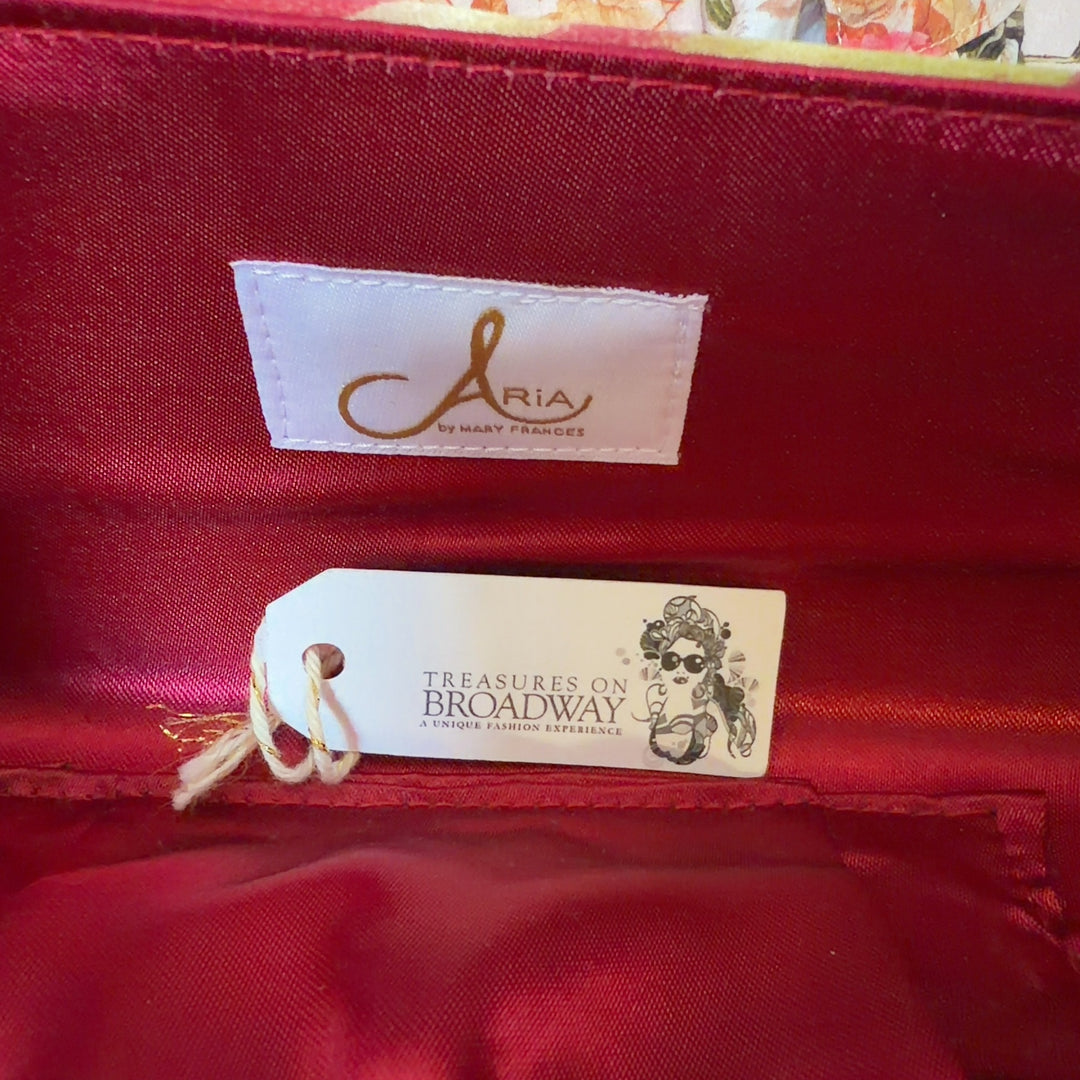 Tag view of cream floral silk shoulder bag with red tie-dye pattern worn as shoulder bag with silver chain strap