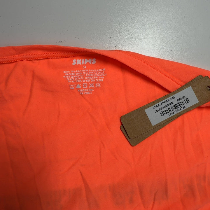 Orange cropped short sleeve top with square neckline and button detailing, back view