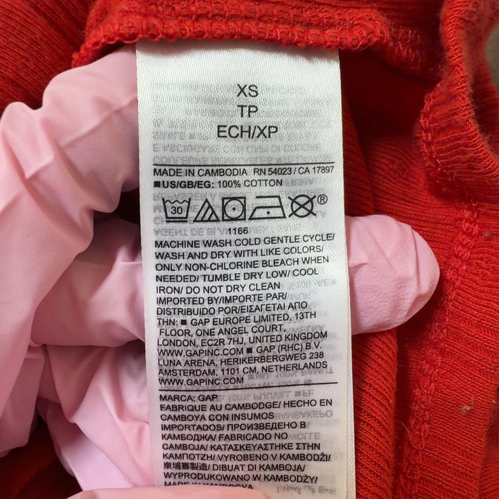 Tag view of red ribbed cotton crop cardigan showing fitted silhouette and cropped length
