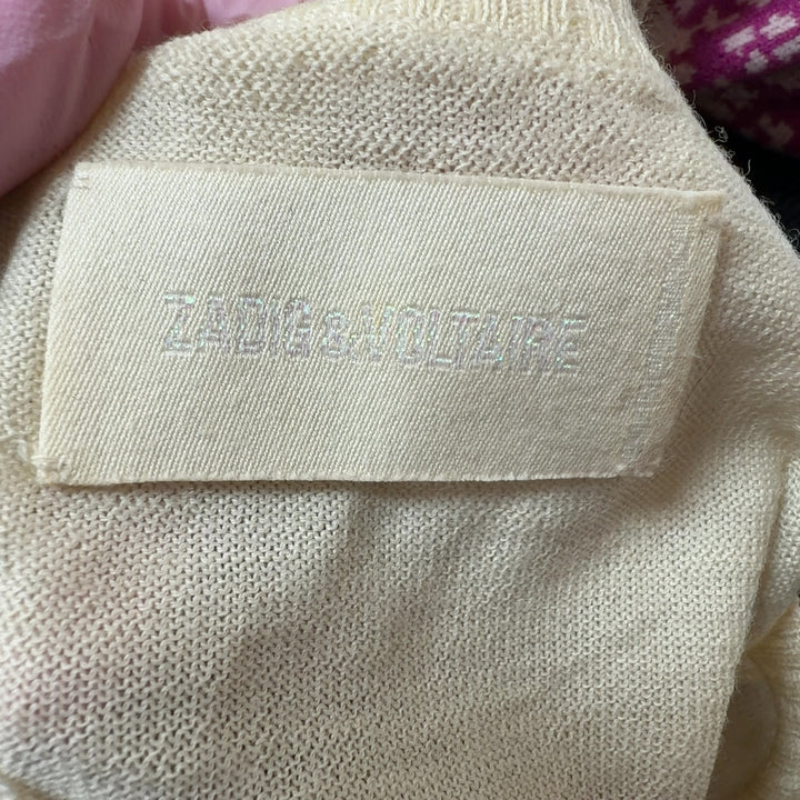 Tag view of cream merino wool sweater showing matching skull graphic design