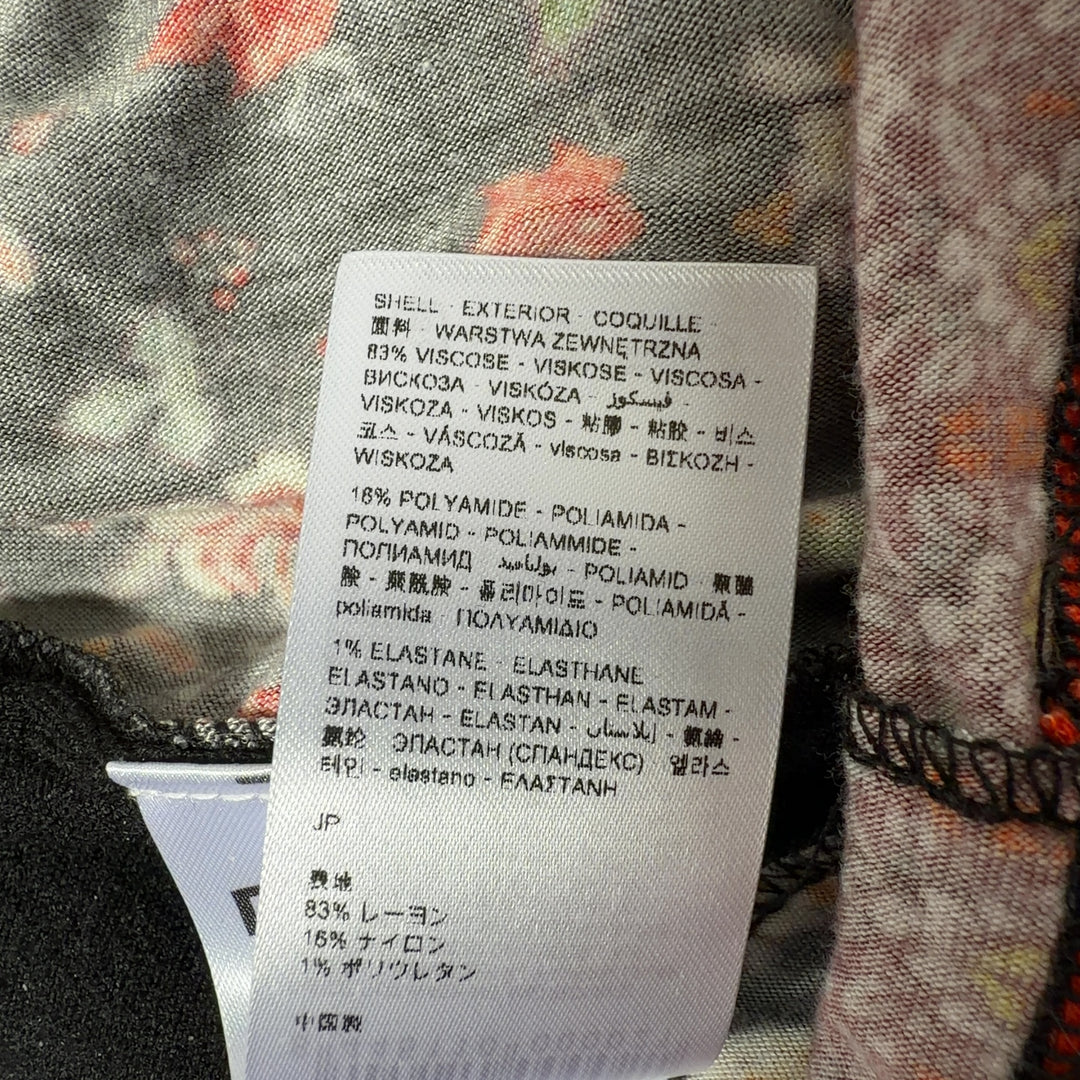 Tag view of black Desigual cardigan showing floral embroidered hem and folk-inspired geometric border pattern