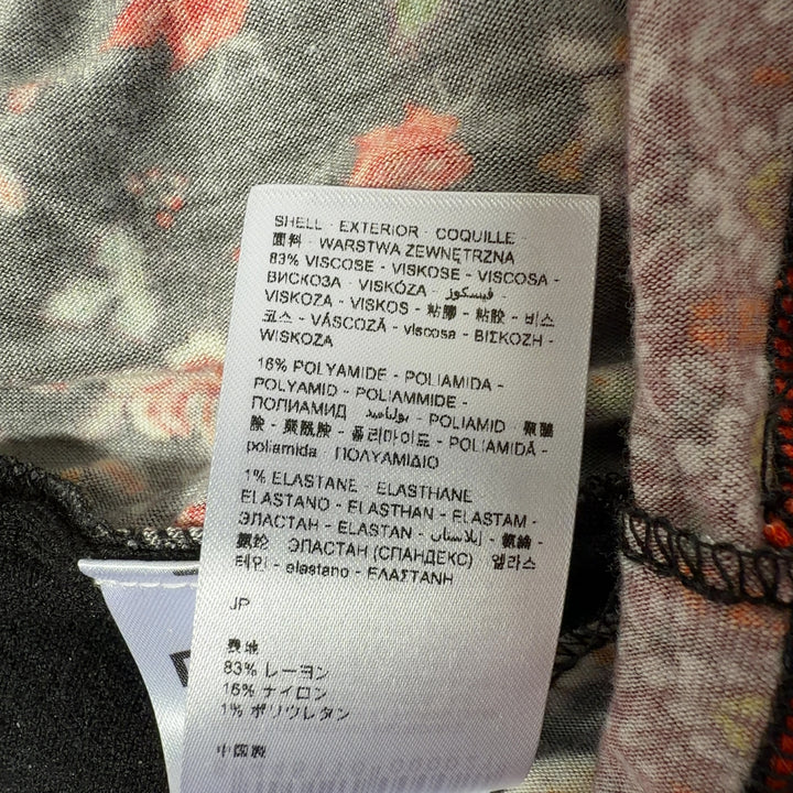 Tag view of black Desigual cardigan showing floral embroidered hem and folk-inspired geometric border pattern