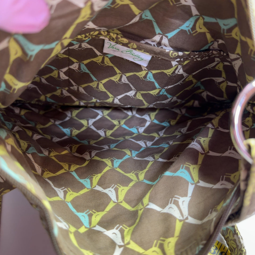Tag view of yellow quilted Vera Bradley crossbody bag worn across body showing rear pocket detail