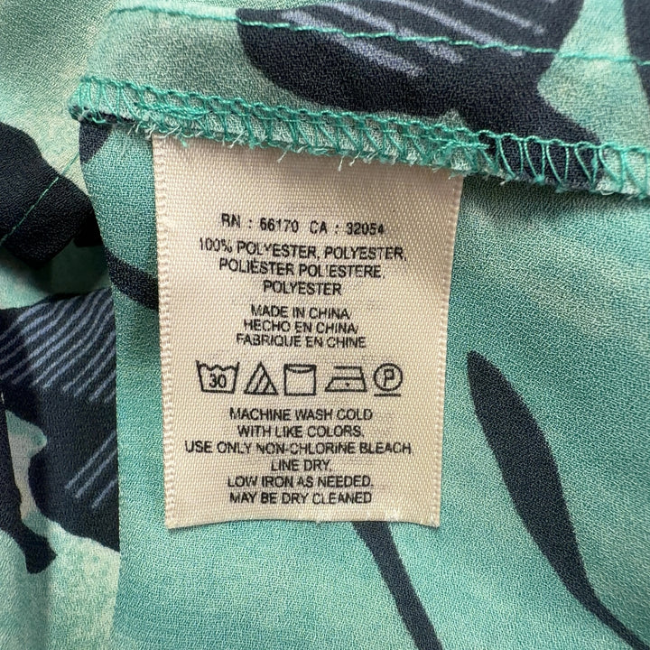 Mint green off-shoulder Maeve top with black floral botanical print, back view showing ruffled sleeves
