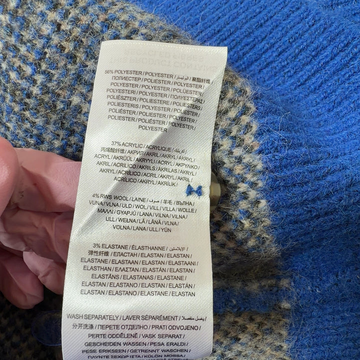 Tag view of blue argyle knit vest showing full argyle pattern design and sleeveless cut