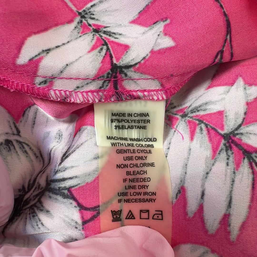 Tag view of pink floral hi-low blouse showing flowing hemline and botanical print design