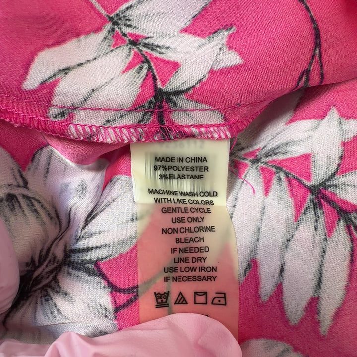 Tag view of pink floral hi-low blouse showing flowing hemline and botanical print design