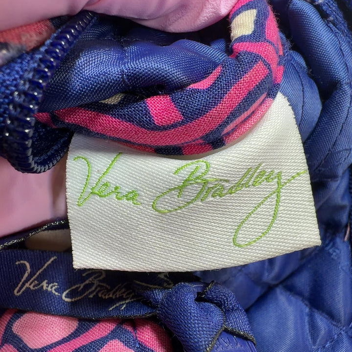 Pink diamond quilted Vera Bradley crossbody bag worn on shoulder, displaying back view and strap detail