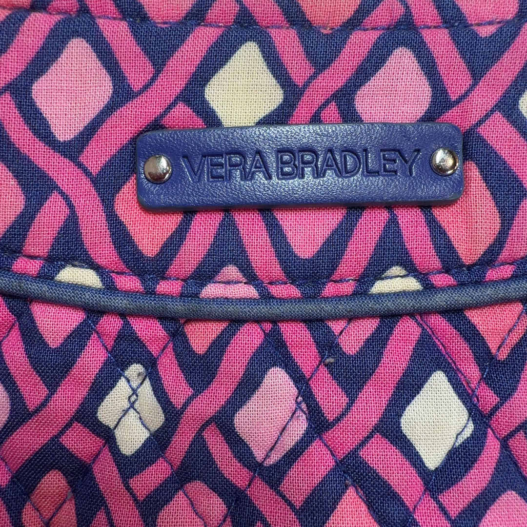 Pink diamond quilted Vera Bradley crossbody bag worn on shoulder, displaying back view and strap detail