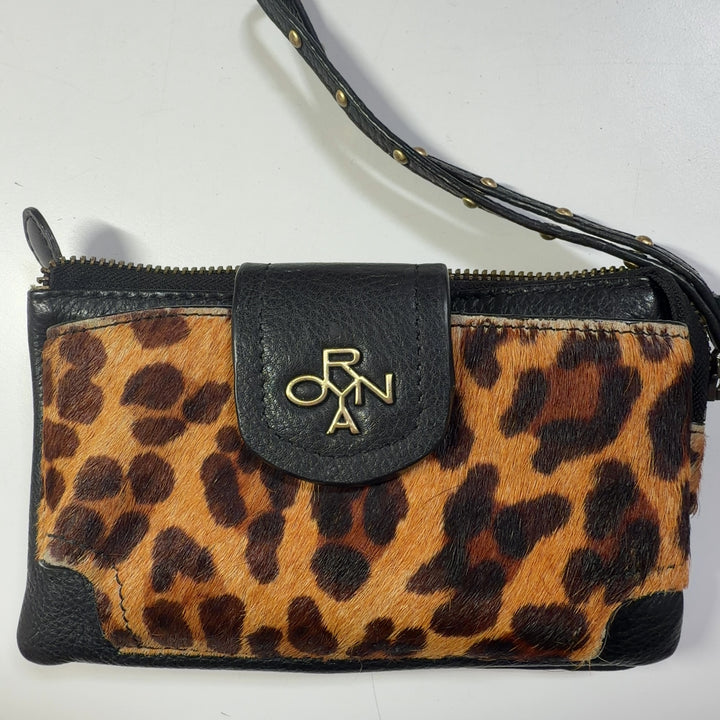 ORYAN leopard print clutch with wristlet strap styled as a fashion accessory worn with black outfit