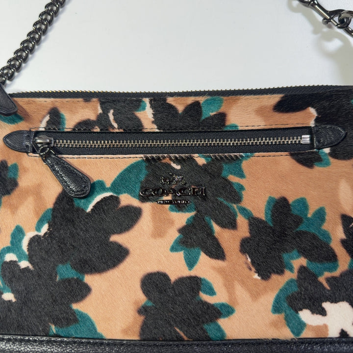 Coach multicolor floral shoulder bag worn as crossbody bag on model wearing black outfit