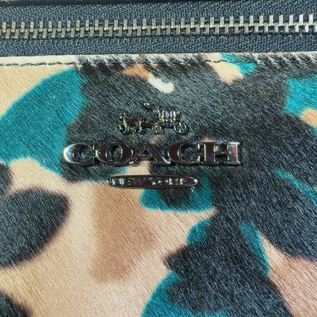 Coach multicolor floral shoulder bag worn as crossbody bag on model wearing black outfit