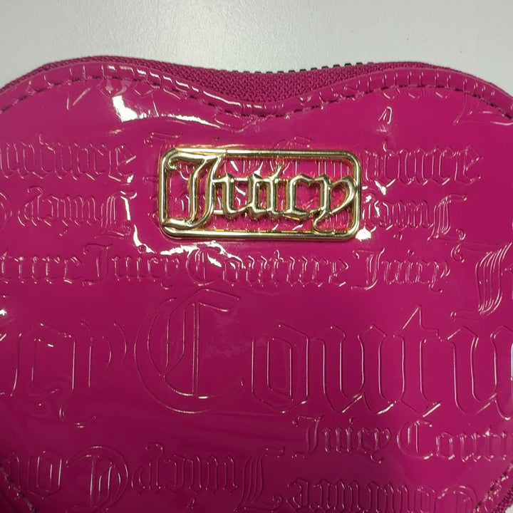 Pink heart-shaped Juicy Couture clutch wristlet worn as accessory with black outfit