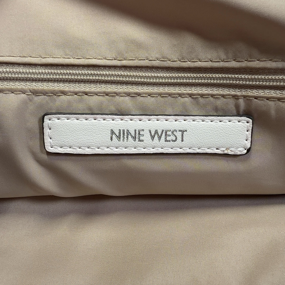 Cream leather shoulder bag by Nine West with pink handles worn on shoulder, back view