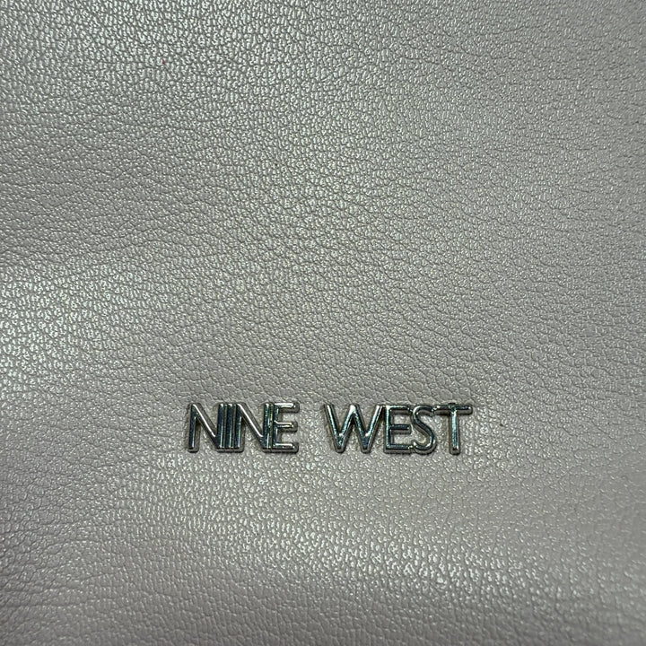 Cream leather shoulder bag by Nine West with pink handles worn on shoulder, back view