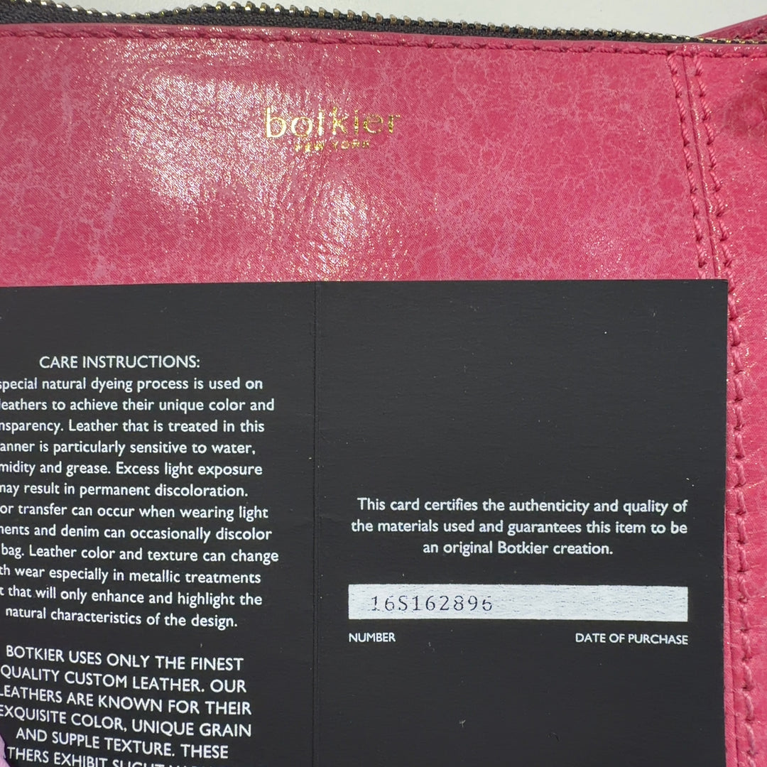 Tag view of coral pink Botkier crossbody bag worn across body, displaying structured silhouette and fringe detailing