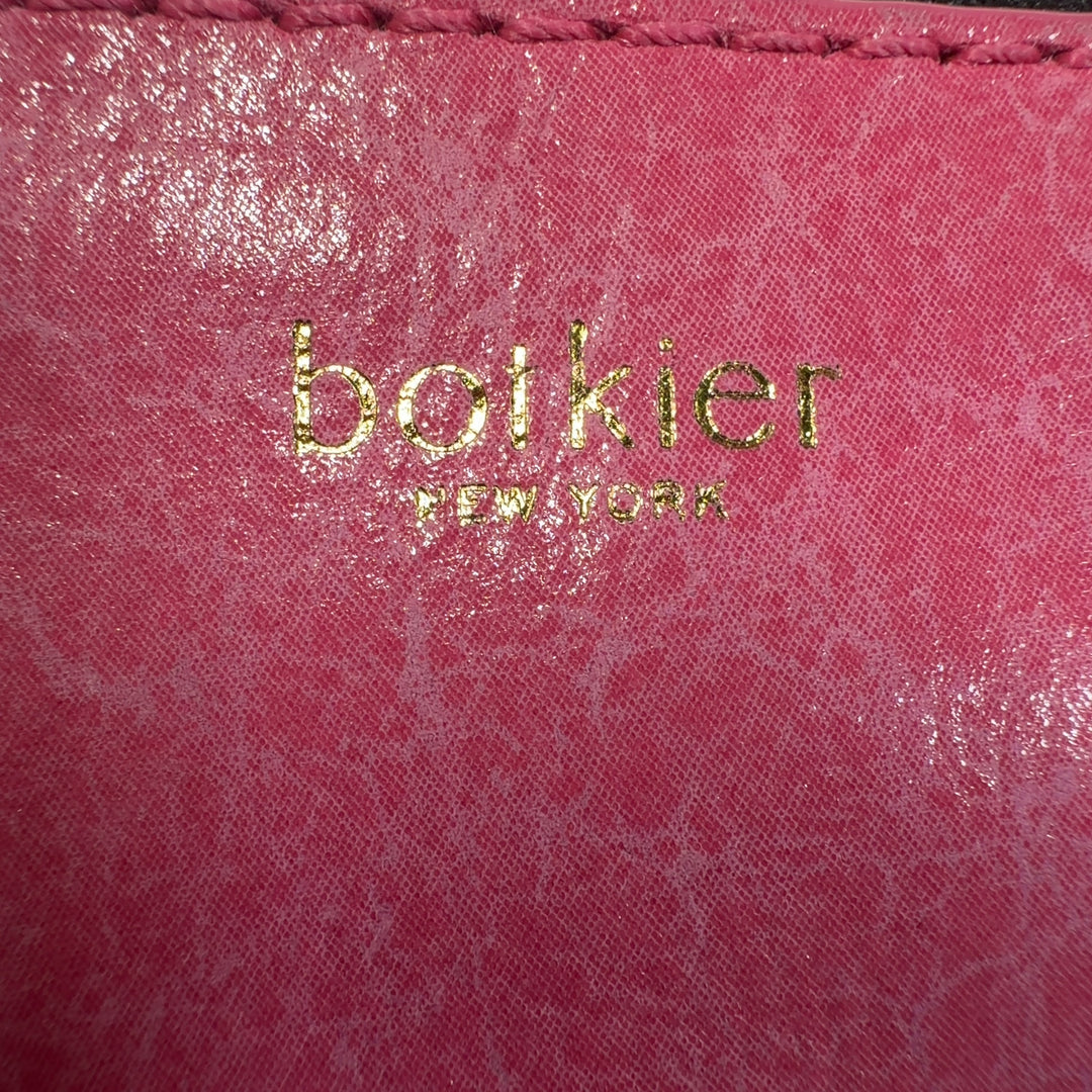 Tag view of coral pink Botkier crossbody bag worn across body, displaying structured silhouette and fringe detailing