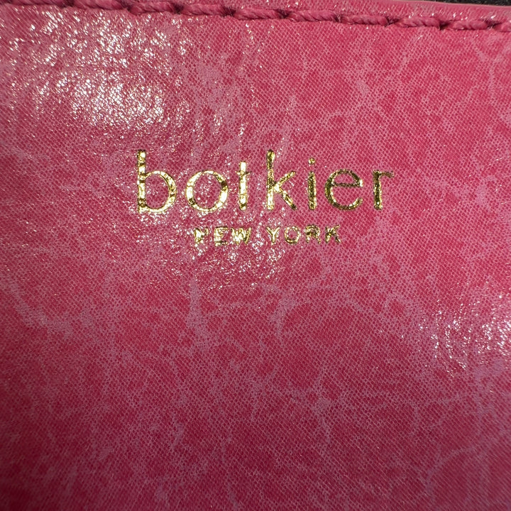Tag view of coral pink Botkier crossbody bag worn across body, displaying structured silhouette and fringe detailing