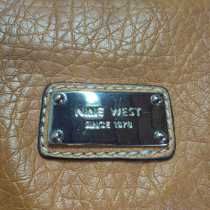 Orange leather crossbody bag worn as crossbody style, back view on model