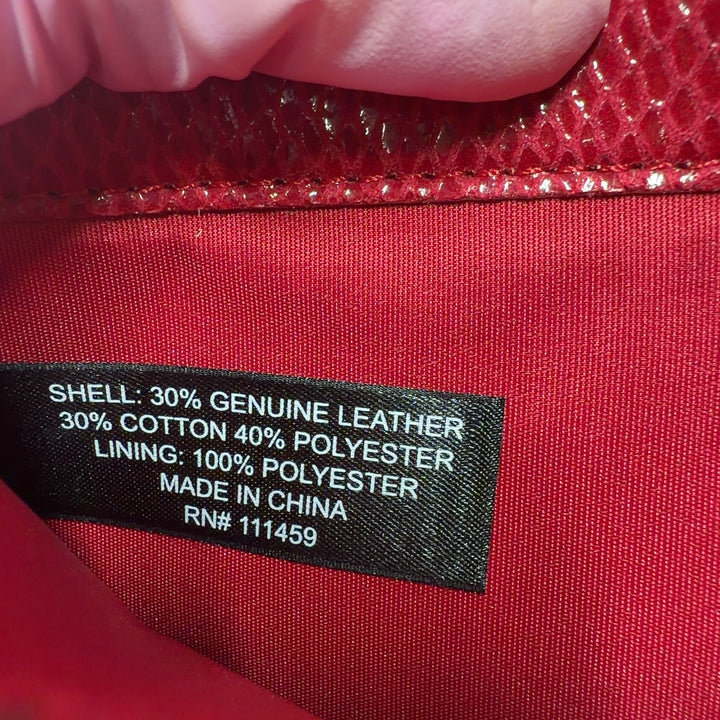 Red leather clutch styled with black outfit, showing back view and gold hardware detail