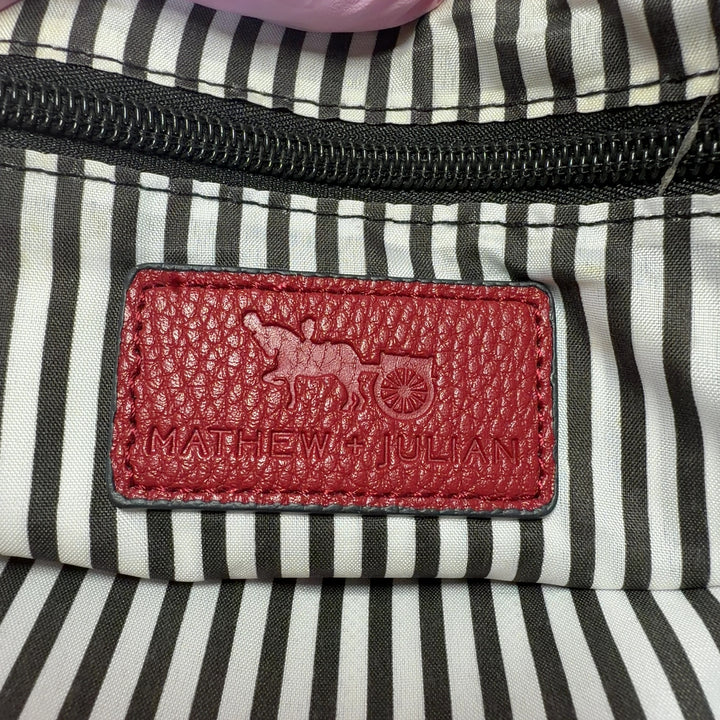 Red leather crossbody bag worn as crossbody style, back view showing strap placement and bag structure