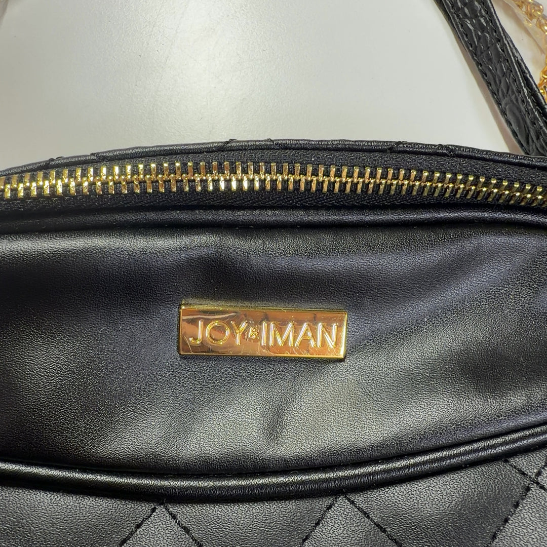 Tag view of black quilted leather shoulder bag worn on shoulder, showing diamond quilting pattern and tassel accent