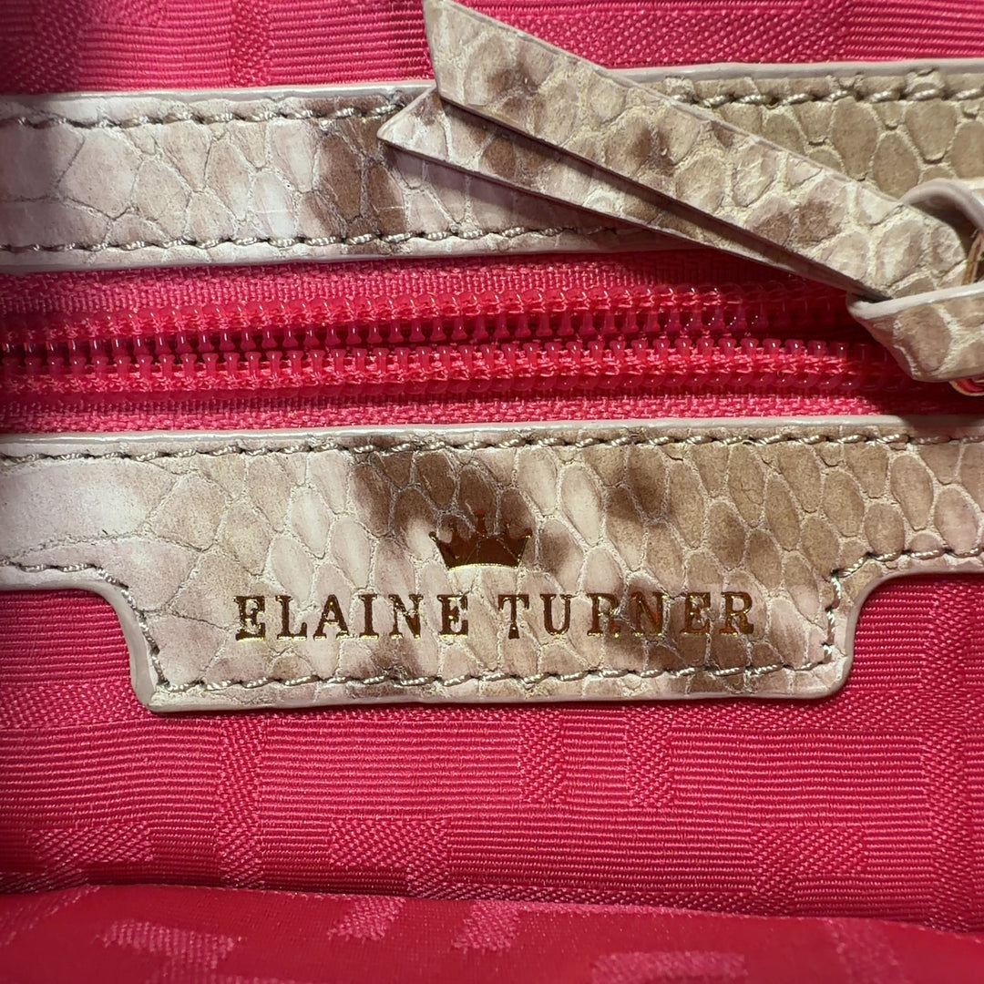 Tag view of cream velvet Elaine Turner shoulder bag worn as shoulder bag, showing structured silhouette and chain strap detail