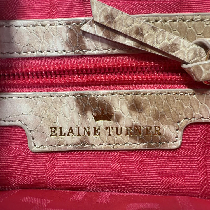 Tag view of cream velvet Elaine Turner shoulder bag worn as shoulder bag, showing structured silhouette and chain strap detail