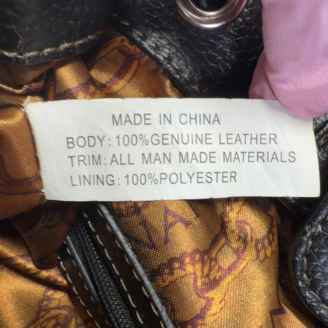 Tag view of black leather Tignanello shoulder tote bag worn on shoulder showing spacious interior and quality construction
