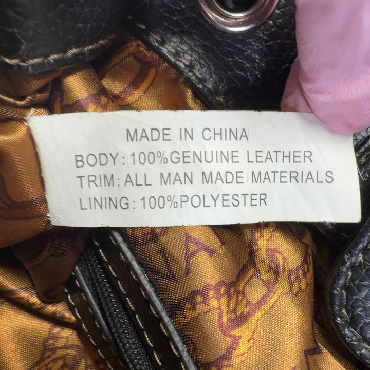 Tag view of black leather Tignanello shoulder tote bag worn on shoulder showing spacious interior and quality construction