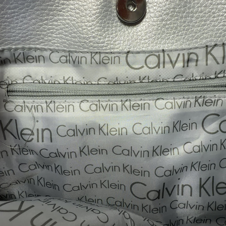 Beige linen Calvin Klein tote bag with white handles and trim, back view on model