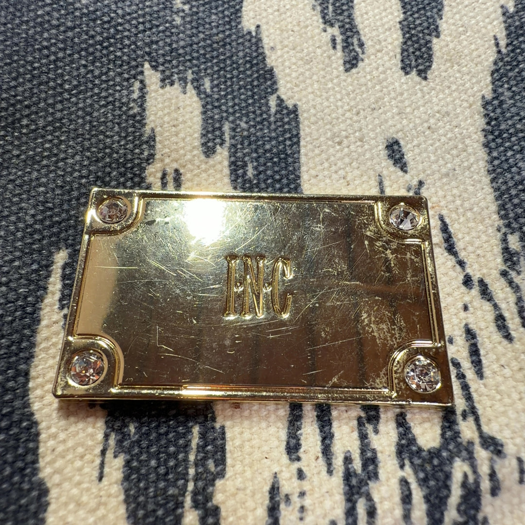 Tag view of gray ikat shoulder bag worn as crossbody style on model