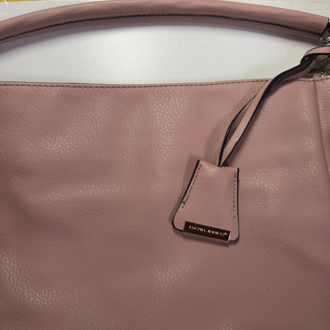 Blush pink leather crossbody bag worn as crossbody style with adjustable strap across body