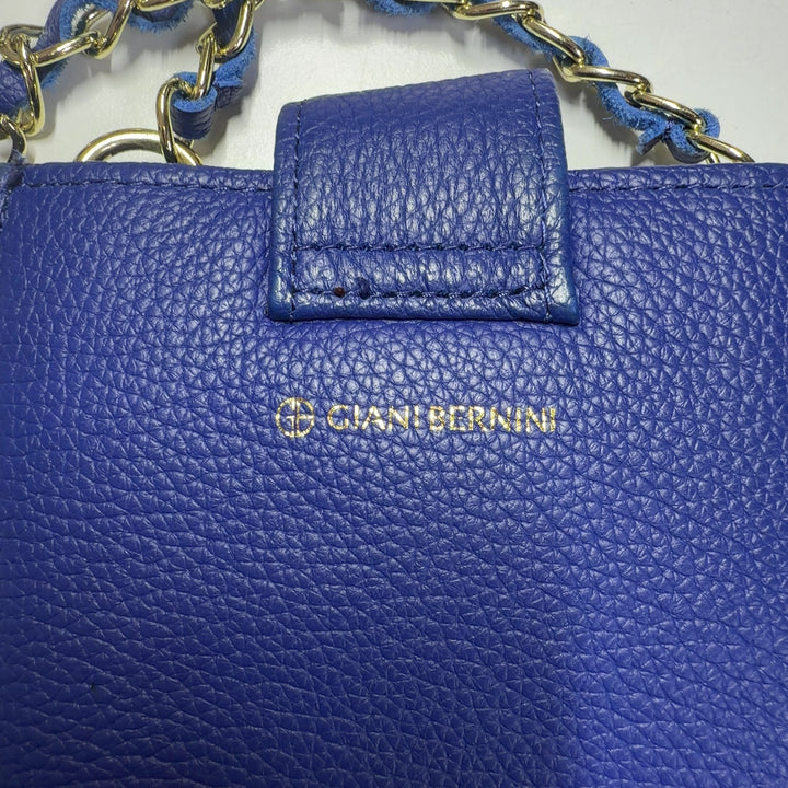 Navy blue textured crossbody bag with chain strap worn across body on model