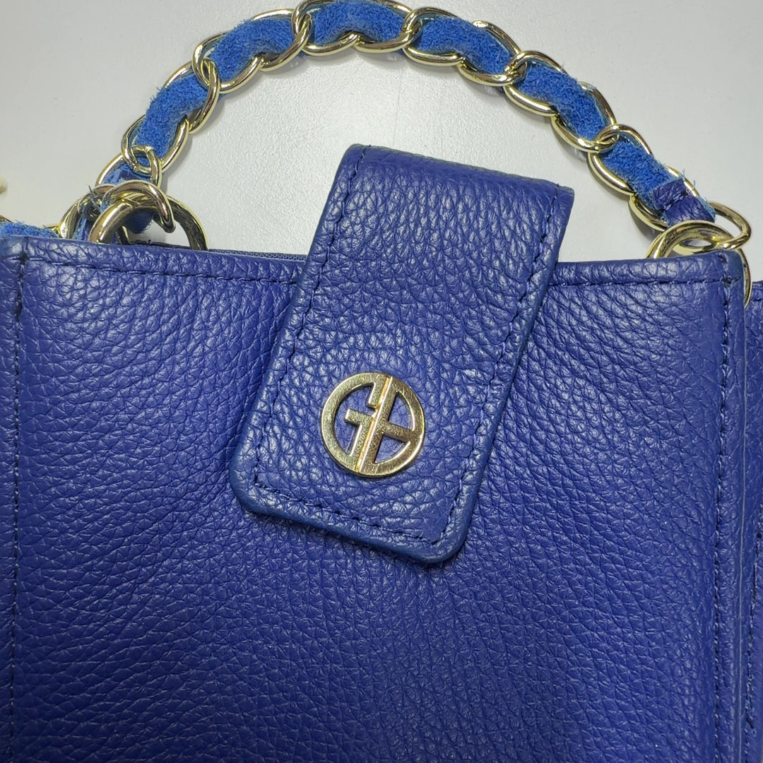Navy blue textured crossbody bag with chain strap worn across body on model
