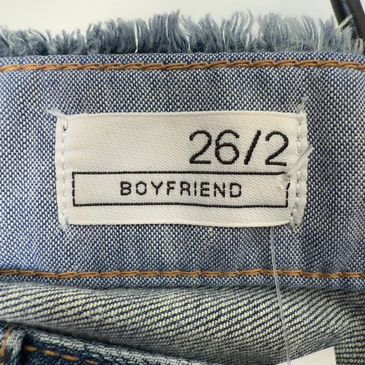 Blue denim distressed shorts back view, showing classic five-pocket styling and fit on model