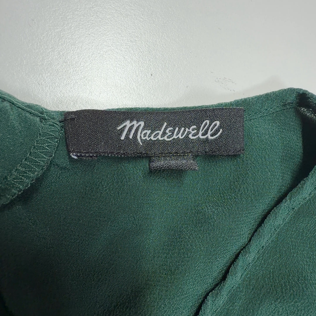 Tag view of green silk ruffle sleeve blouse showing layered sleeve detail and relaxed silhouette