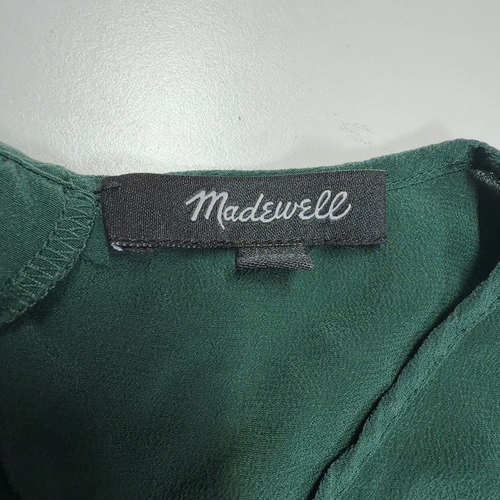 Tag view of green silk ruffle sleeve blouse showing layered sleeve detail and relaxed silhouette