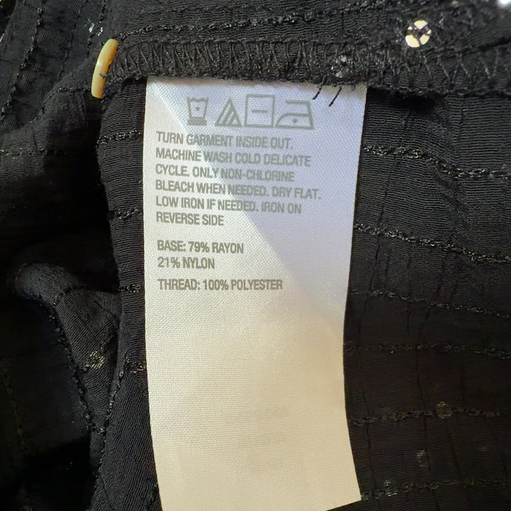 Tag view of black sequin shirt dress showing high-low hemline and oversized silhouette