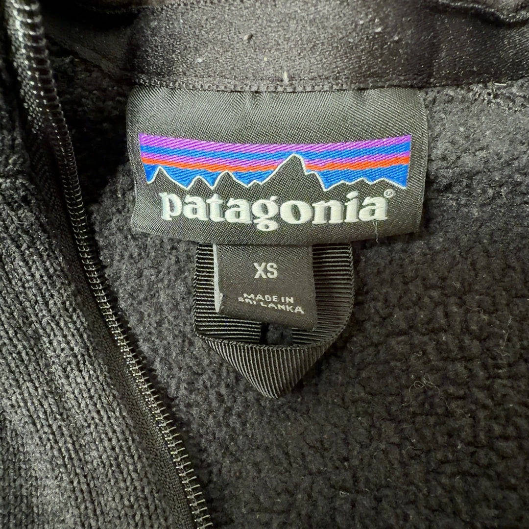 Patagonia black recycled polyester zip-up hoodie back view on model, showing fitted silhouette and side pockets